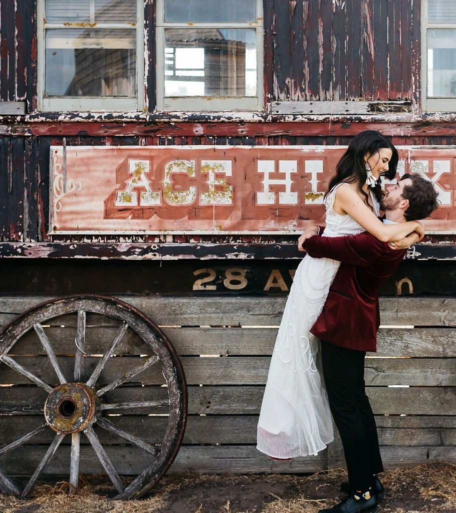 Wedding couple hug in front of Ace-Hi signage.